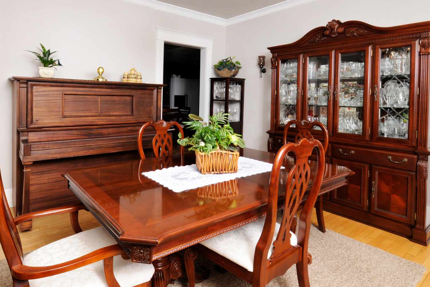 Formal dining room with a wooden table chairs a piano and a glass cabinet