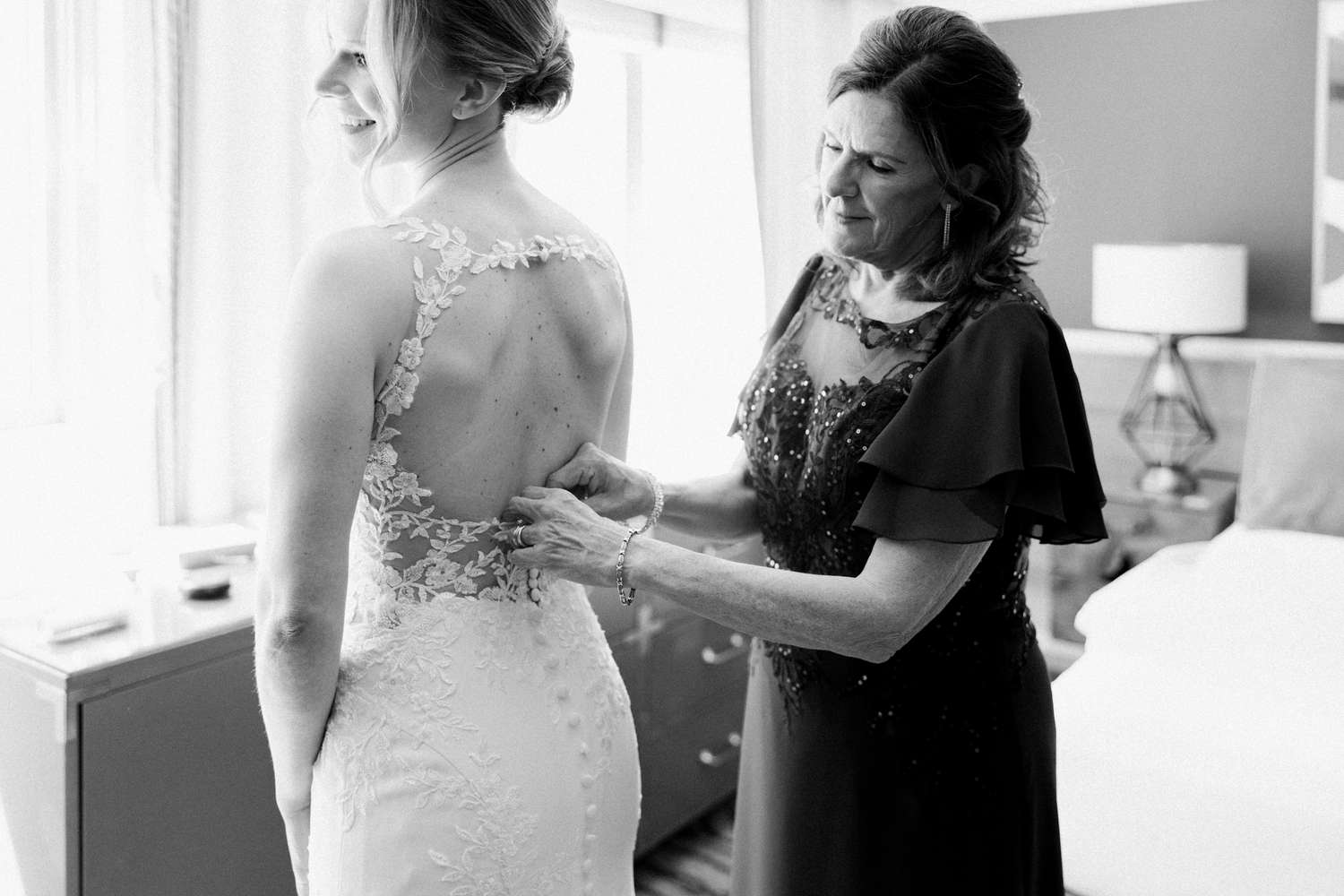 Woman helping bride with dress