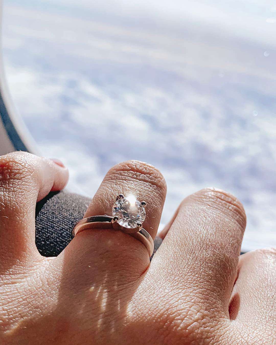 engagement ring selfie airplane window view of clouds