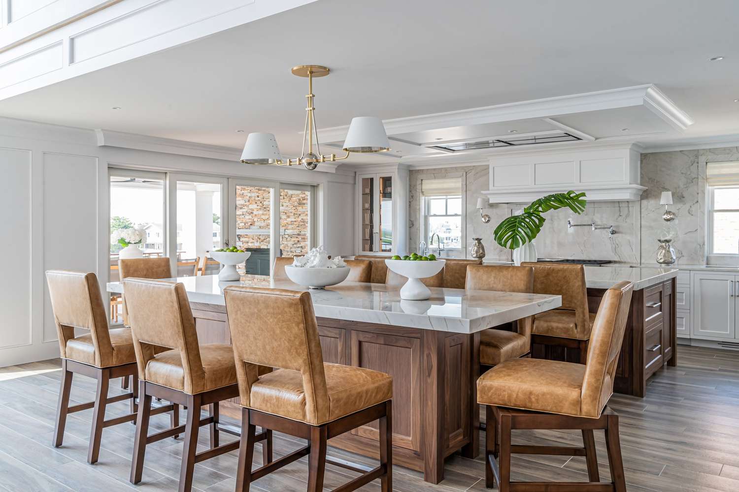 Open kitchen with a central island and bar stools modern furnishings and natural light from large windows