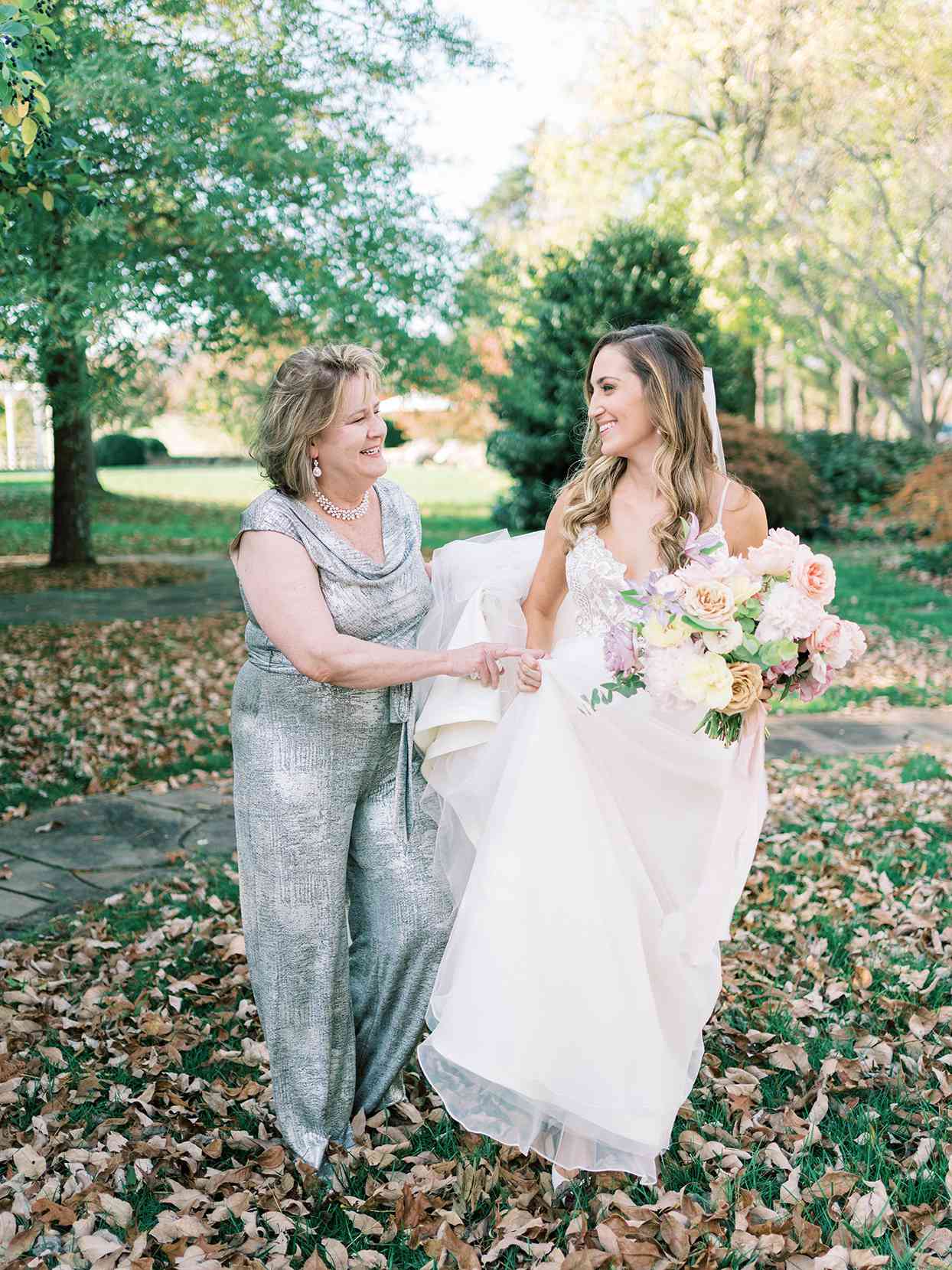bride and mother laughing and preparing to walk down the aisle