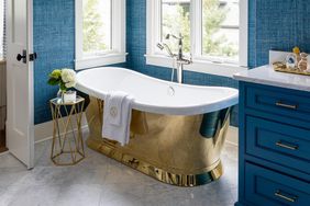 brass bathtub in blue bathroom
