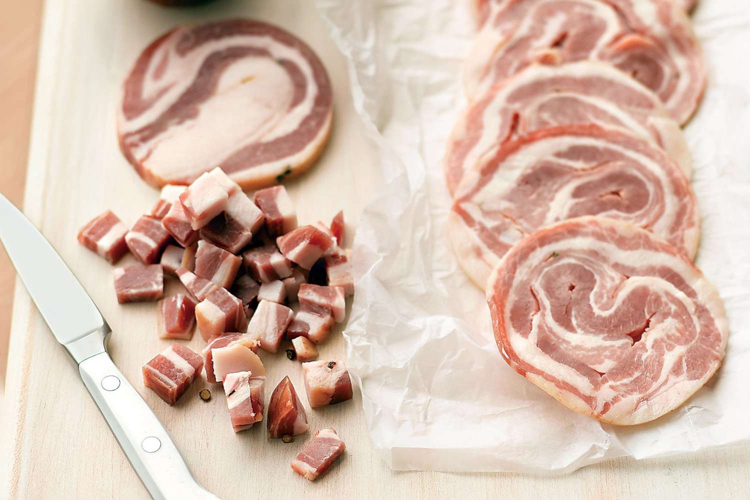 Pancetta sliced on cutting board
