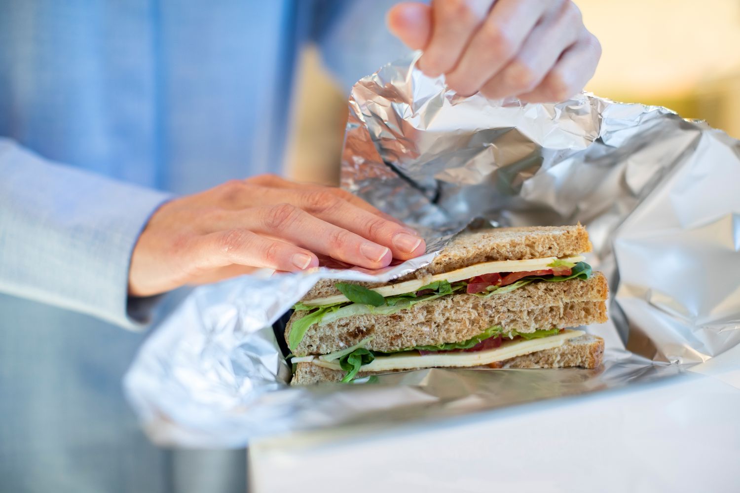 woman wrapping sandwich with aluminum foil