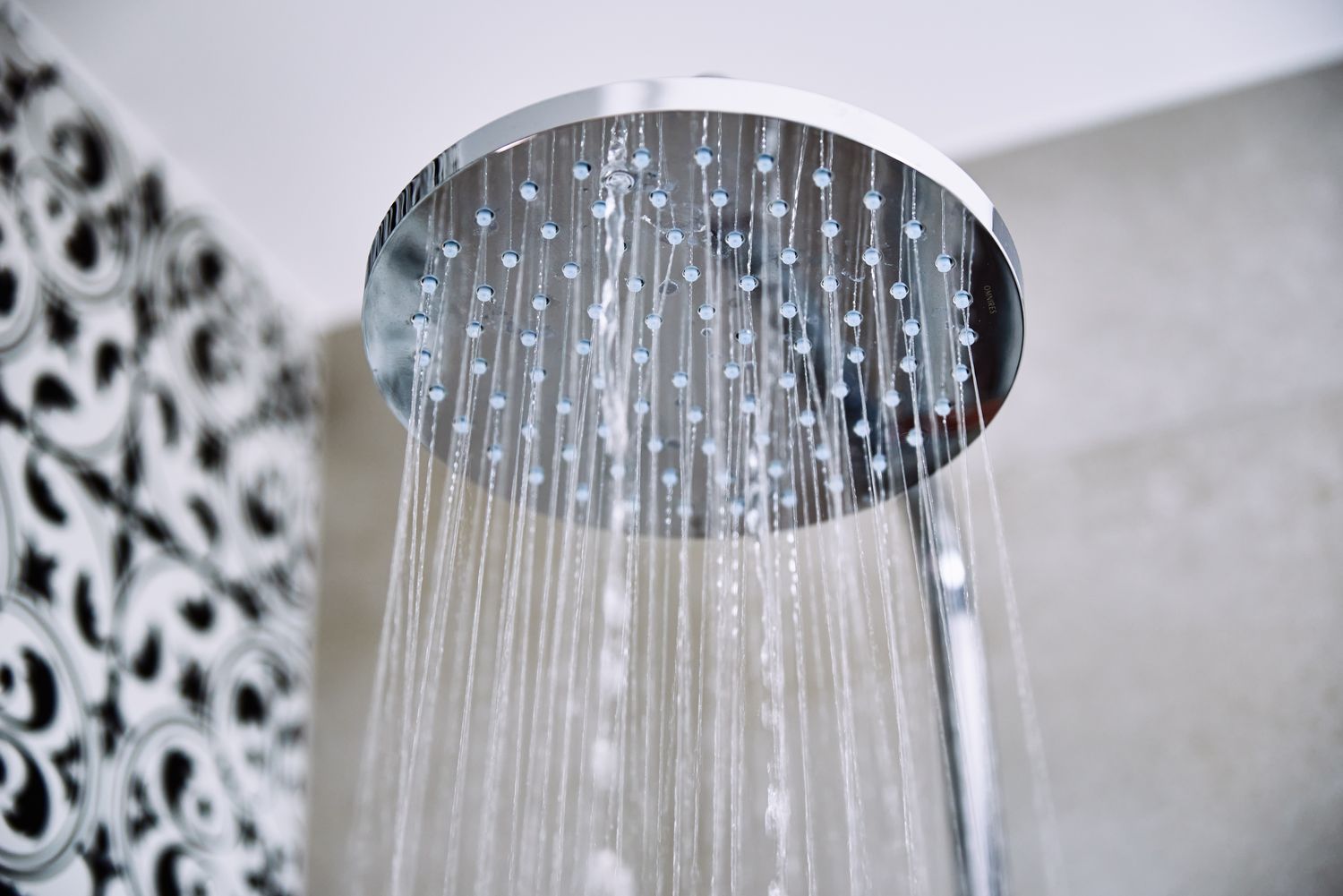 Overhead showerhead spraying water in a bathroom