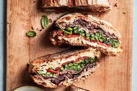 pressed sandwich with prosciutto and broccoli rabe recipe on wooden cutting board
