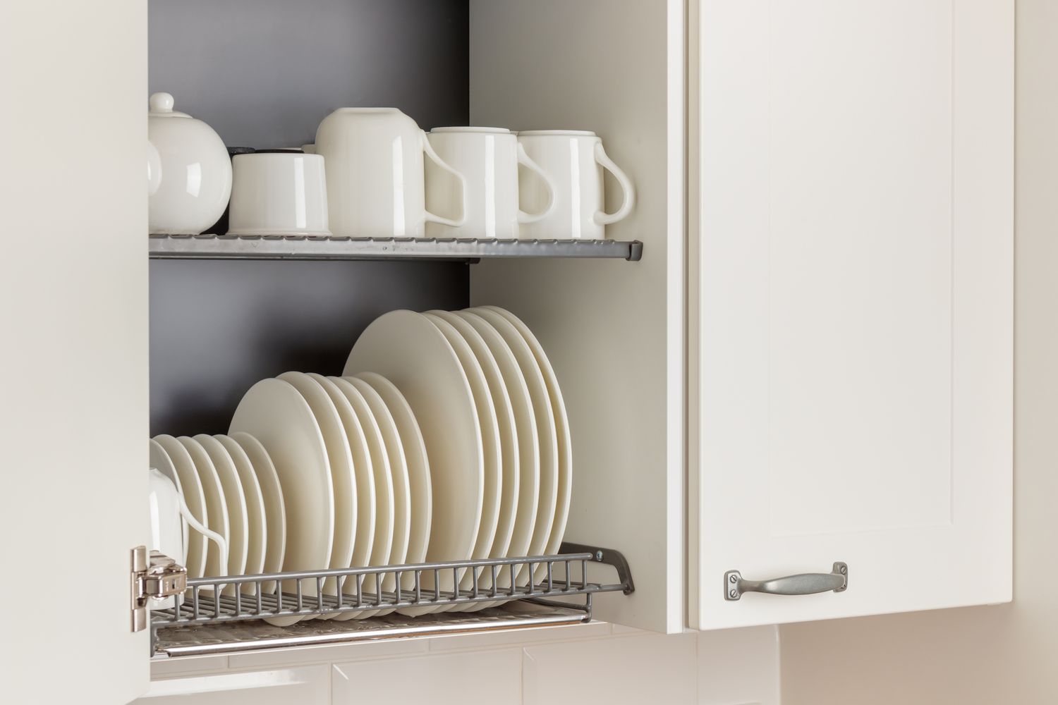 Sliding metal basket organizer in kitchen cabinet