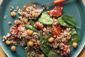 bulgur with chickpeas, spinach, and red peppers on blue-grey plate