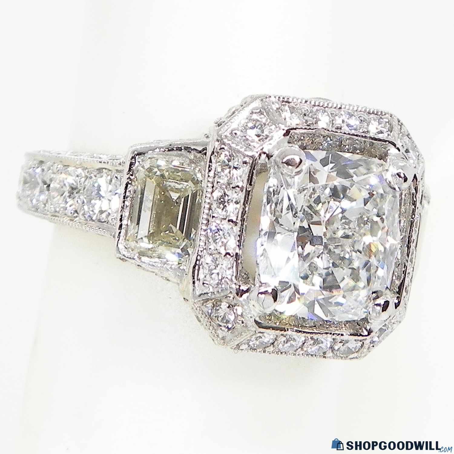 A diamond ring with intricate detailing and a prominent squarecut centerpiece