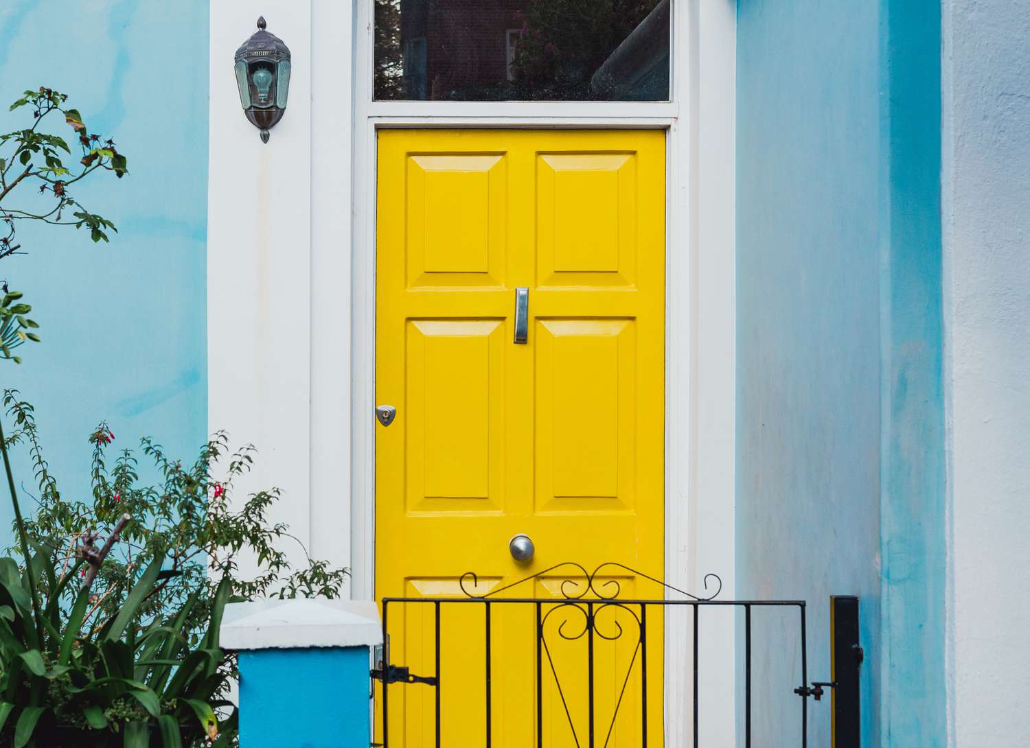 yellow front door on a blue house