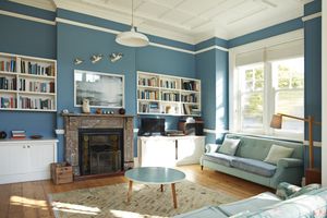 A cozy living room with bookshelves a fireplace a sofa and a round coffee table