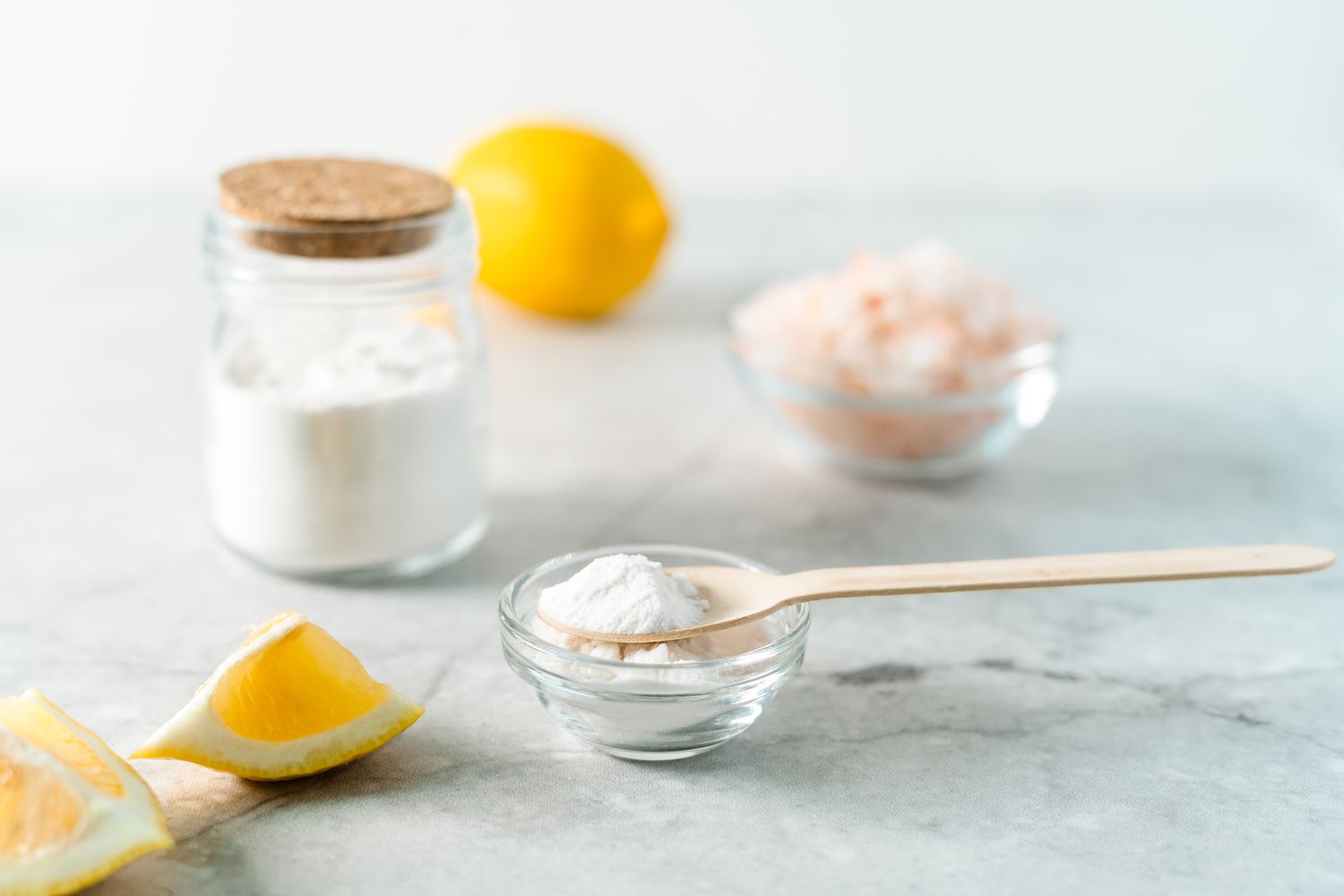 Powder in a bowl surrounded by lemons. 