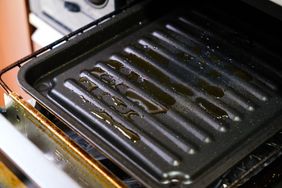 A greasy broiler pan inside an oven