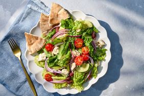 Plate of Greek salad with pita on a blue napkin