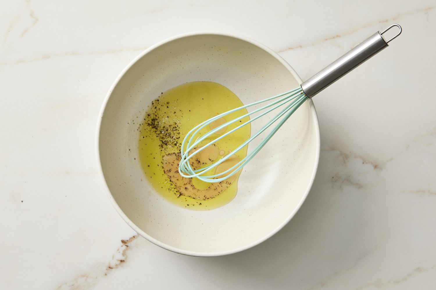 Oil salad dressing in bowl with whisk