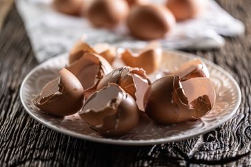 Eggshells on a plate broken and empty on a wooden table