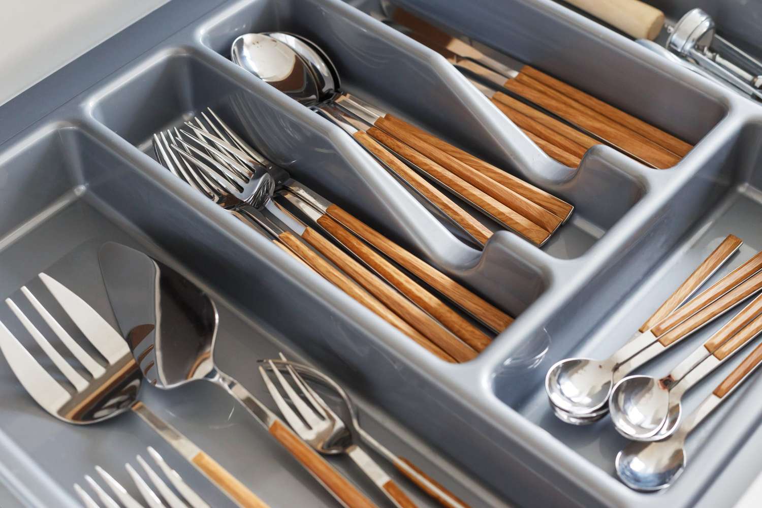 Stylish cutlery with wood-effect handles in organizer.