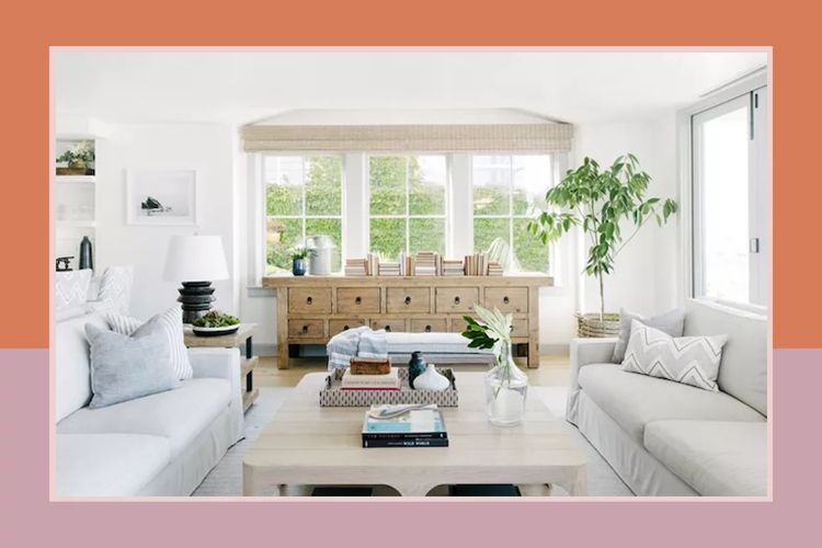 A bright and airy living room featuring a wooden console table sofas and large windows