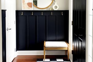 Entry way with gold accents, black wall, checkered rug