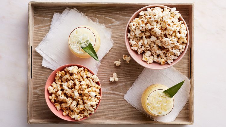 movie-theater-style popcorn served on tray with cocktails