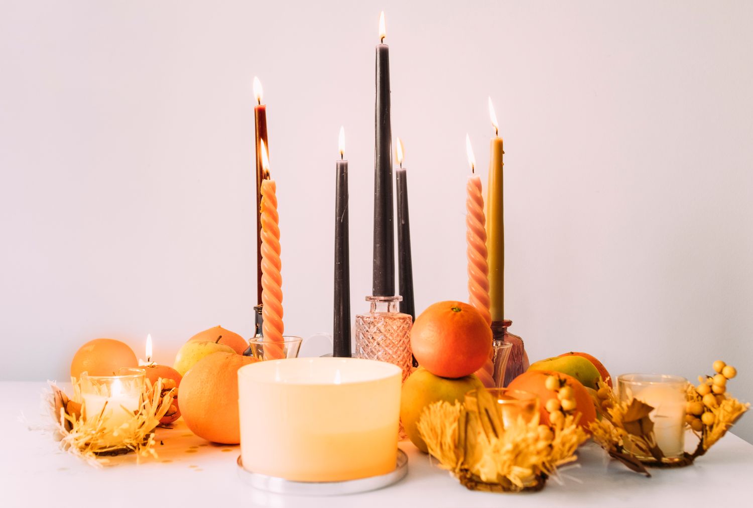 A table setup with lit candles pumpkins and decorative autumnal elements