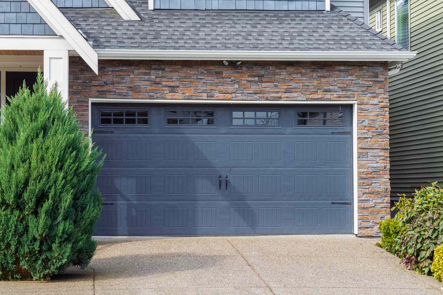 Residential house with a blue garage door and stone facade