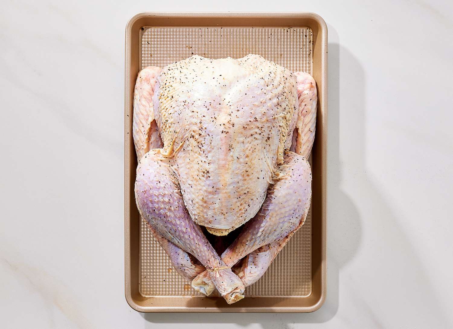 overhead view of raw turkey on sheet pan