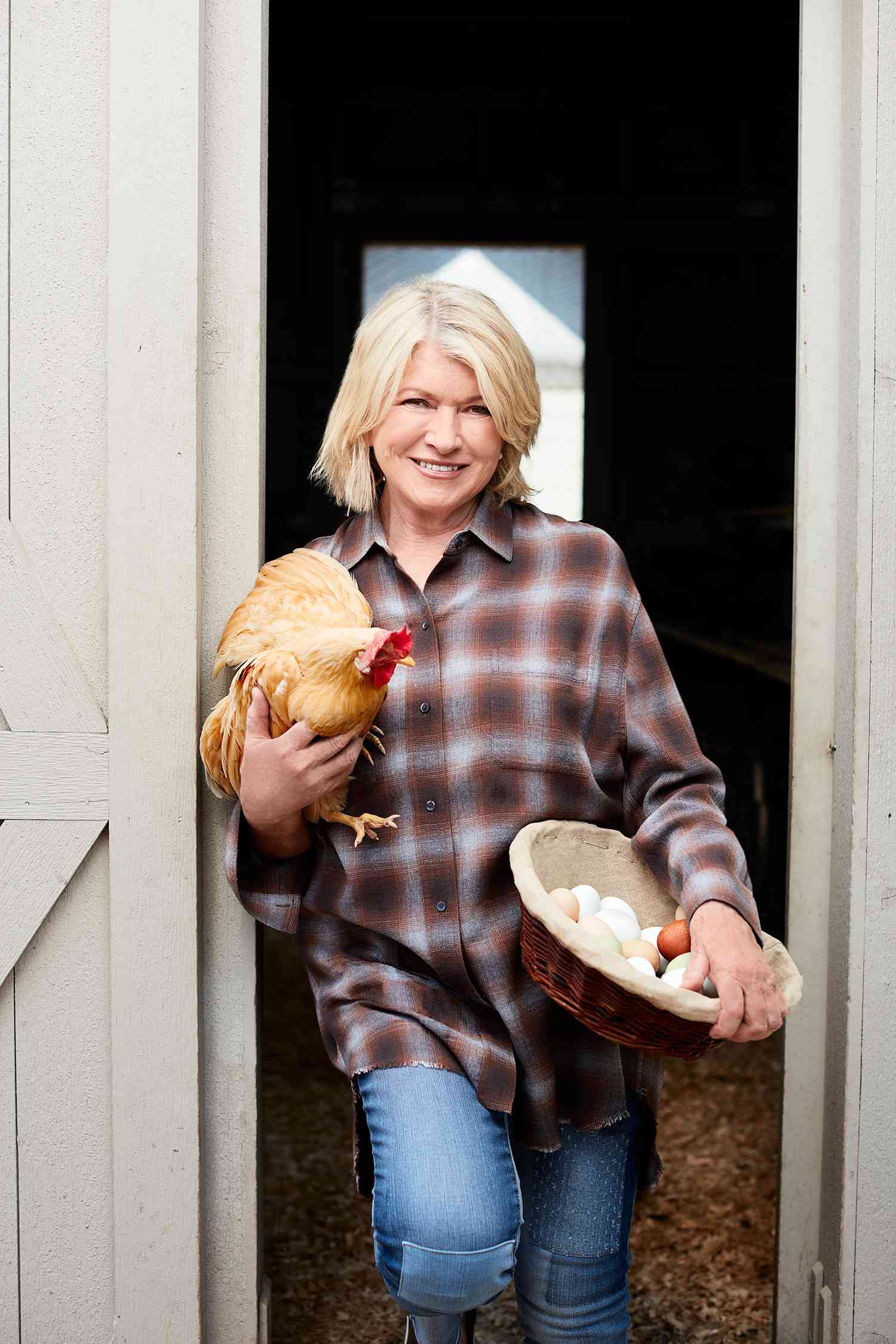 martha holding chicken outside coup