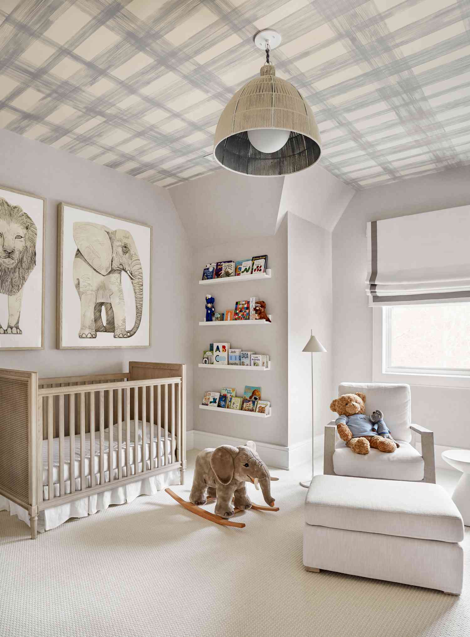 Neutral nursery with animal artwork and book shelves