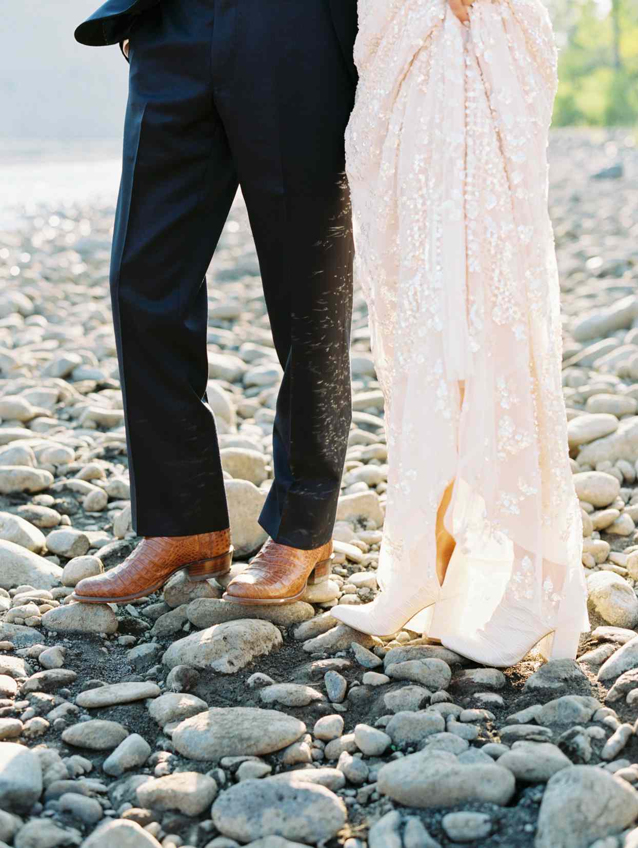 bride and groom where leather boots standing on the rocks