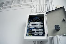 Open electrical circuit breaker panel with wires and switches visible