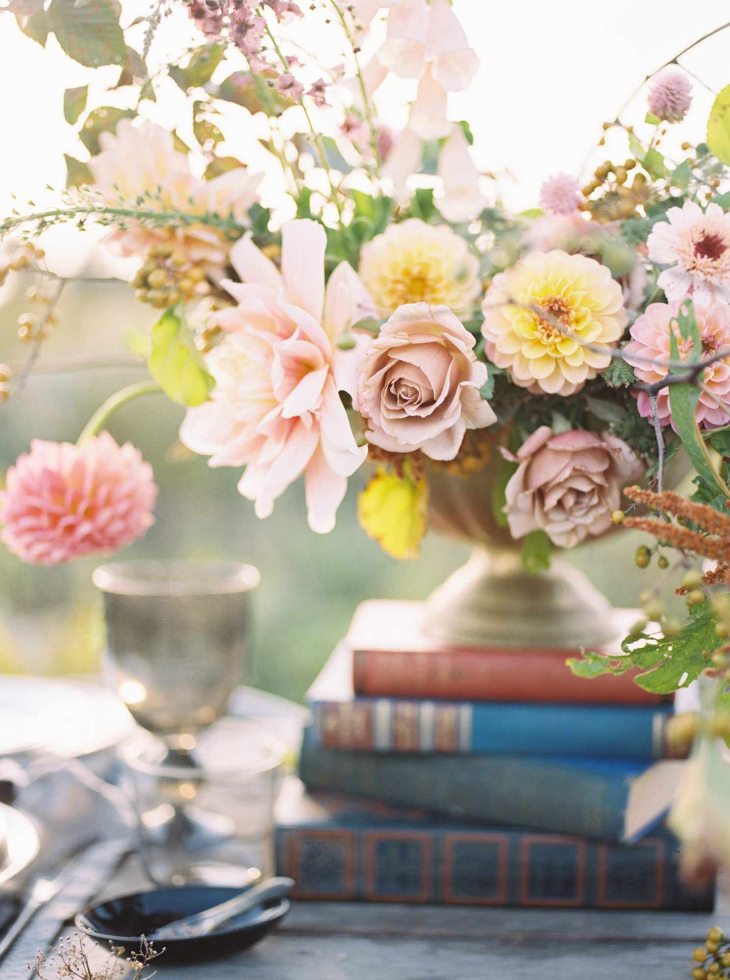 dusty pink garden rose centerpiece on top of vintage books