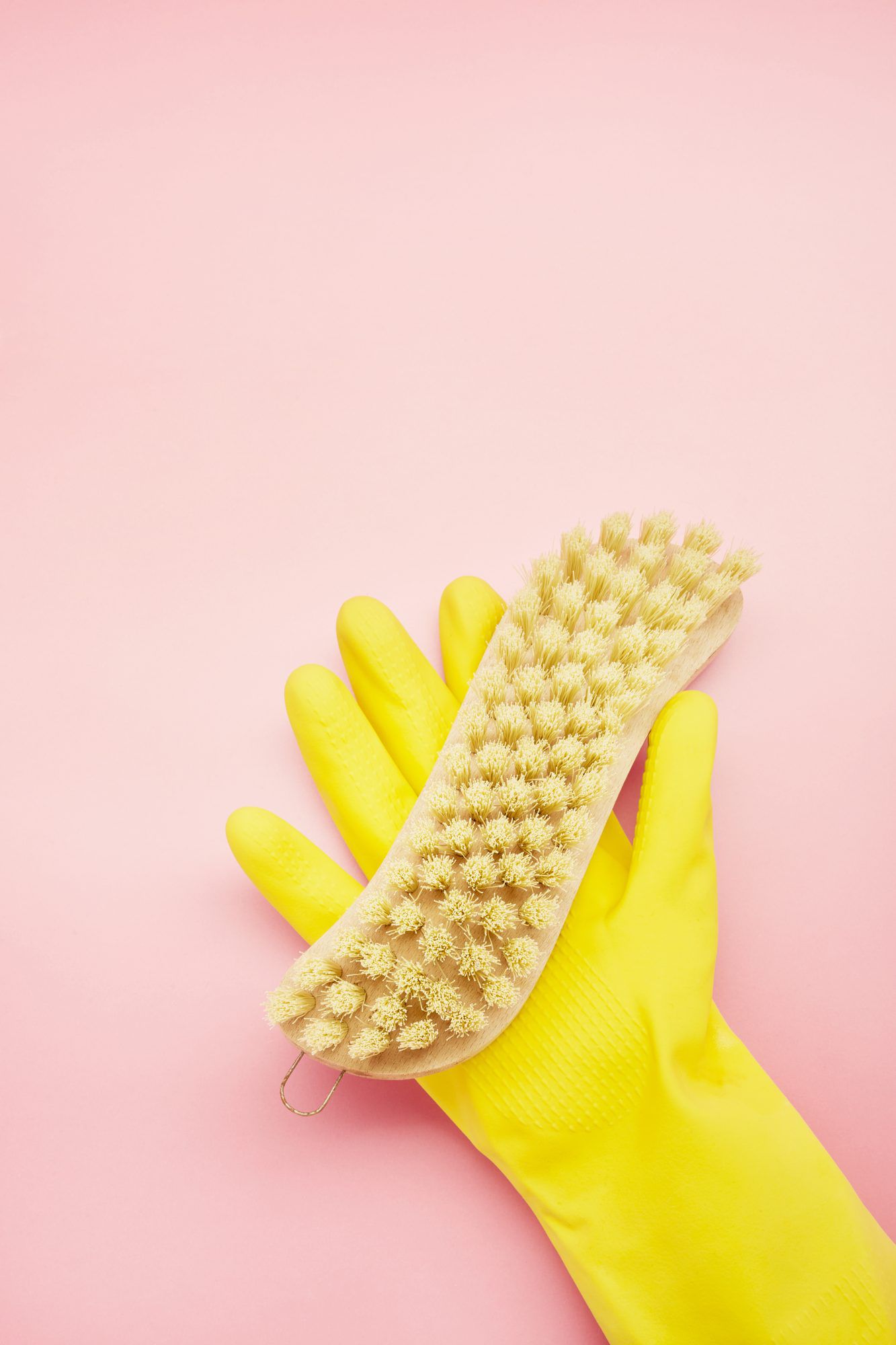 yellow glove holding scrub brush