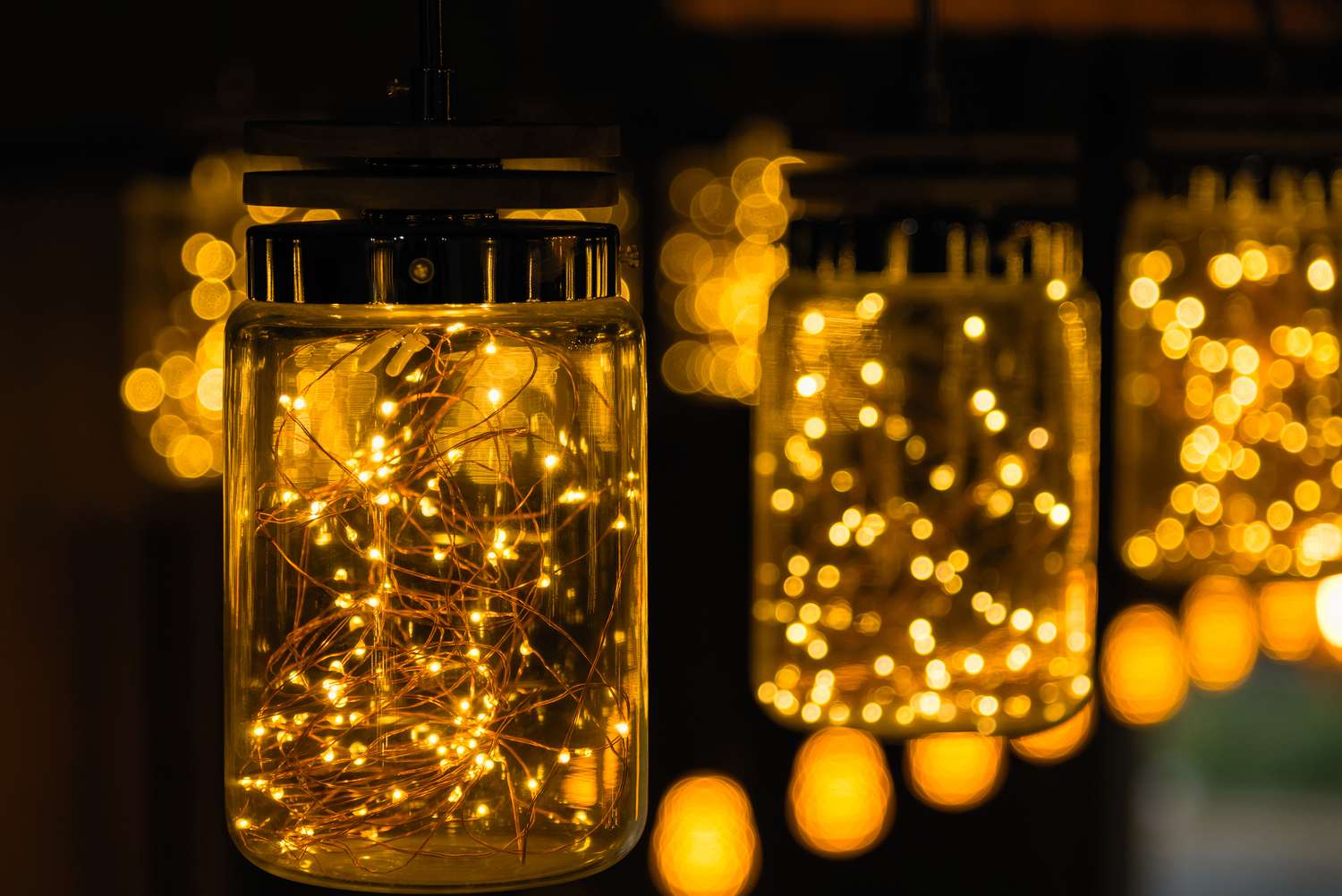 Close-Up Of Illuminated Light Bulbs In Jars