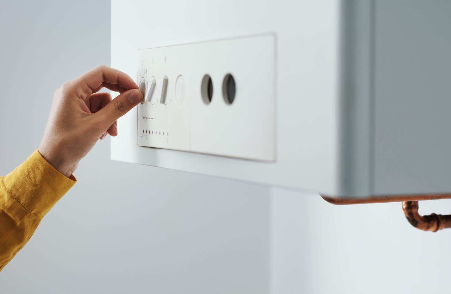 woman checking settings and temperature on the water heater boiler