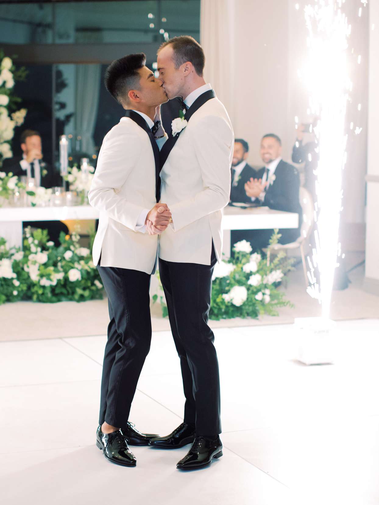 grooms first dance on the dance floor wearing matching white jackets