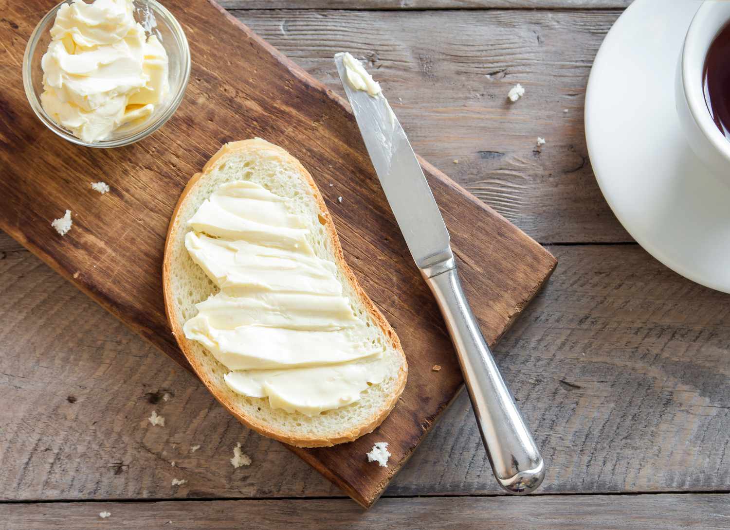 overhead view of bread and butter on a wooden surface