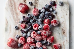 overhead view of frozen berries on a marble cutting board