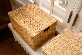 Woven storage baskets on a window sill one open with contents not visible