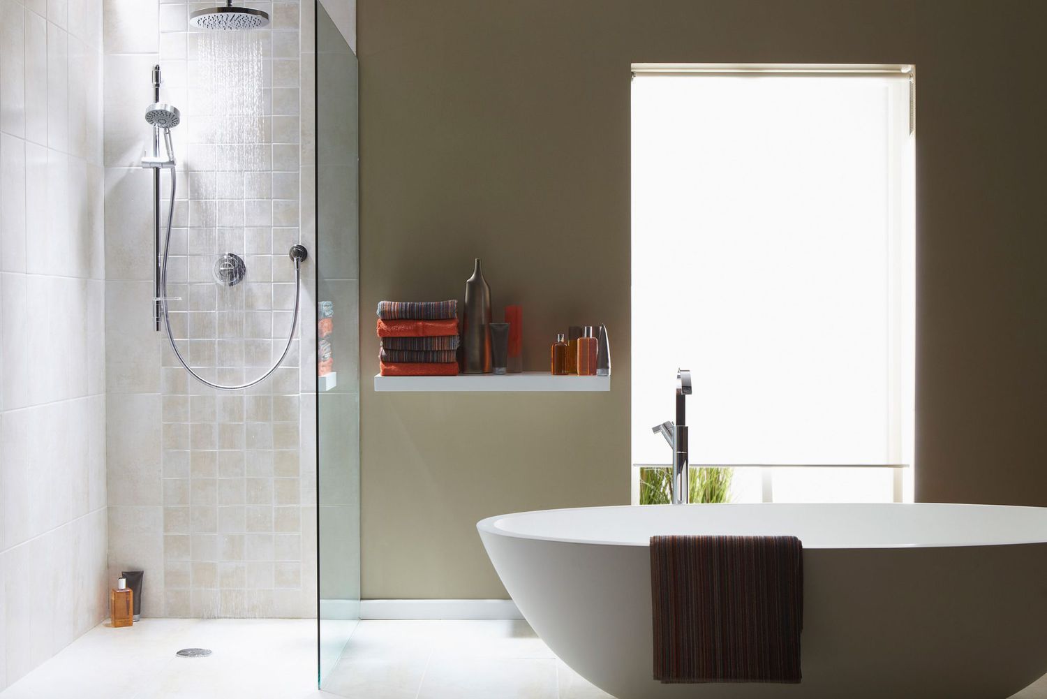 Interior of bathroom in cool gray, green with a running shower