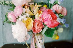 pink-and-white peony bouquet with blush ranunculus, yellow roses, and purple sweet peas