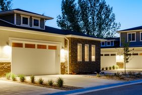 Suburban homes with garages lit at dusk