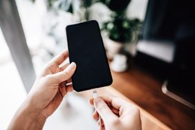 A person plugging a cable into a smartphone