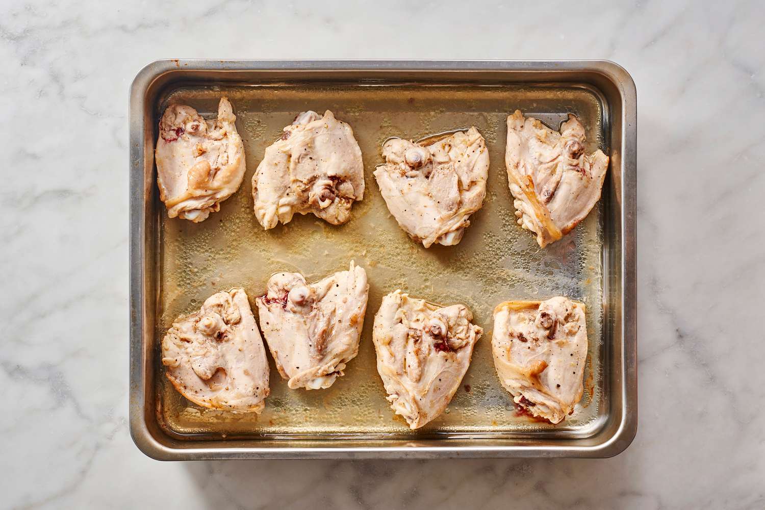 marinated chicken thighs on baking sheet