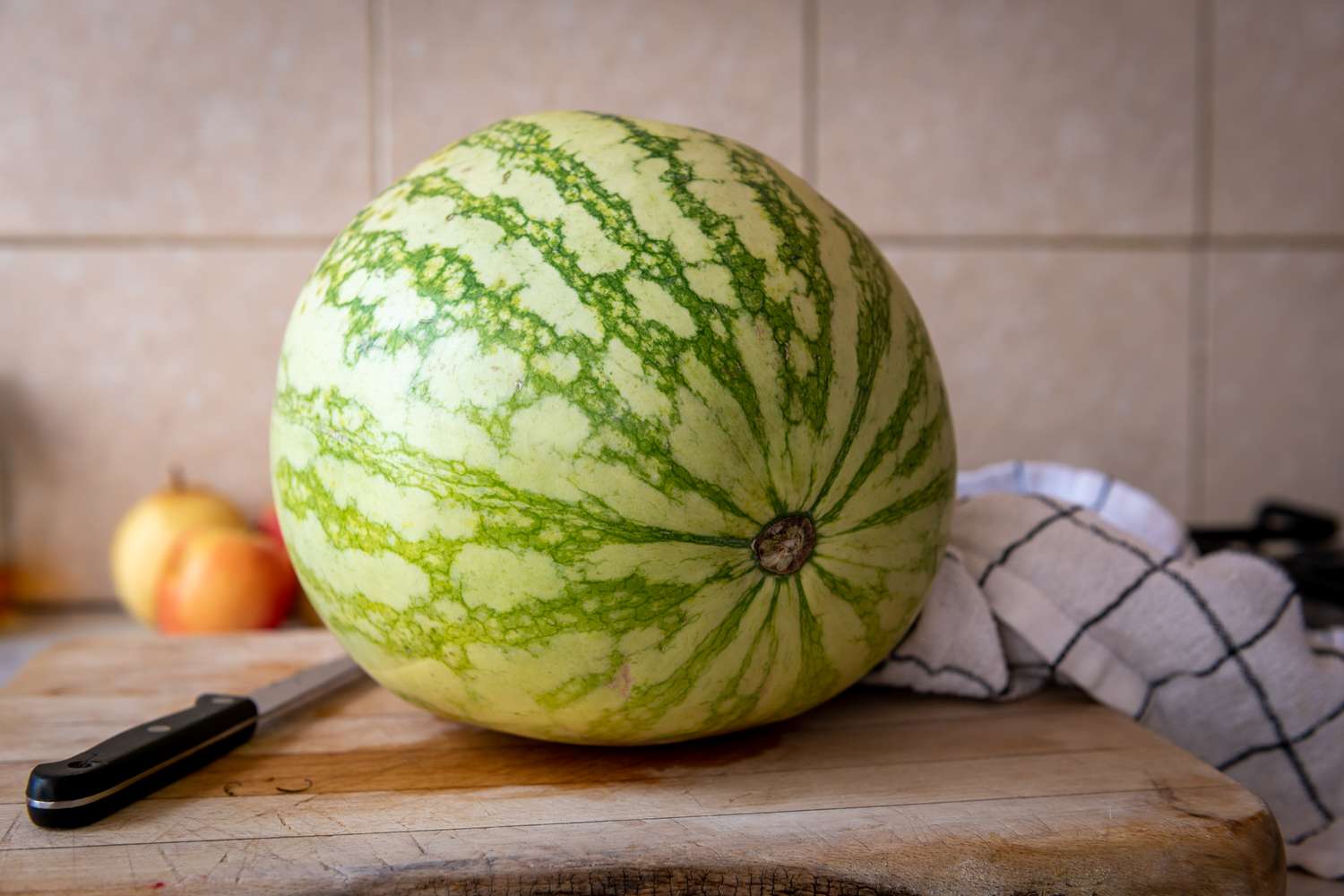 whole watermelon on a wooden board in kitchen
