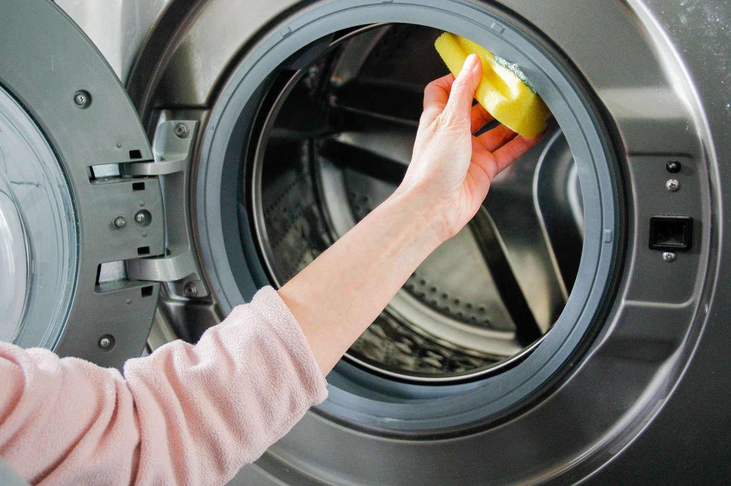 A person cleaning drum of a washing machine or dryer
